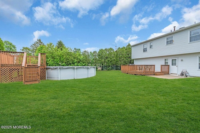 22 Orchard Ct, Howell, NJ 07731 - view of green lawn with a wooden deck, an outdoor pool, and a patio