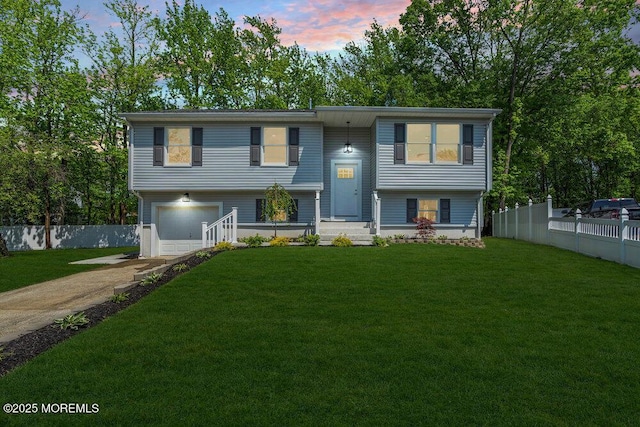 bi-level home with concrete driveway and an attached garage