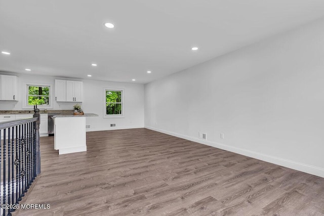 unfurnished living room featuring recessed lighting, wood finished floors, and baseboards