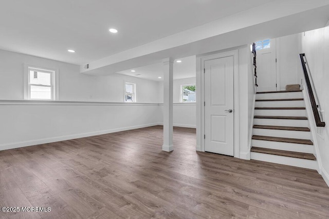 basement with wood finished floors, recessed lighting, baseboards, and stairway