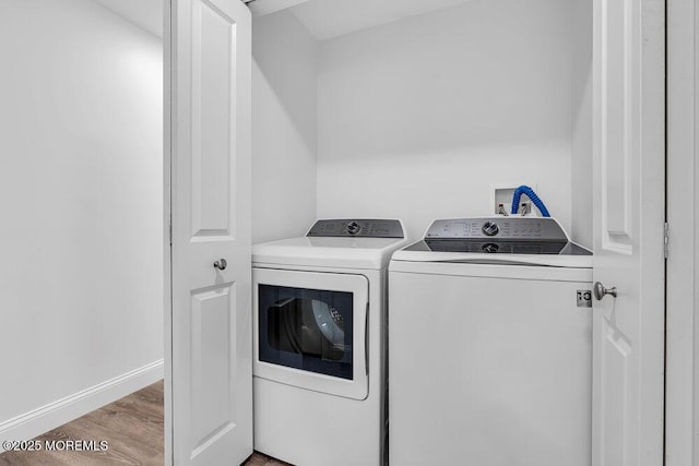 washroom featuring separate washer and dryer, wood finished floors, and baseboards
