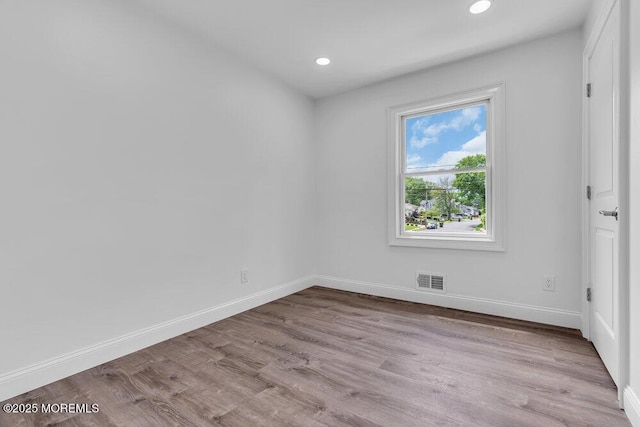 unfurnished room with recessed lighting, baseboards, and wood finished floors