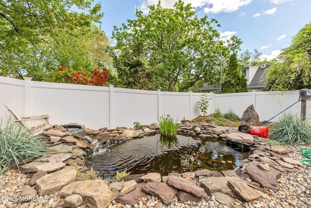 fenced backyard with a small pond