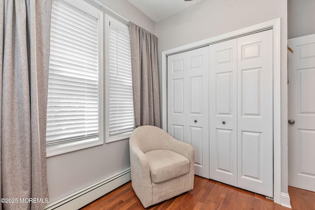 sitting room with baseboard heating and wood finished floors