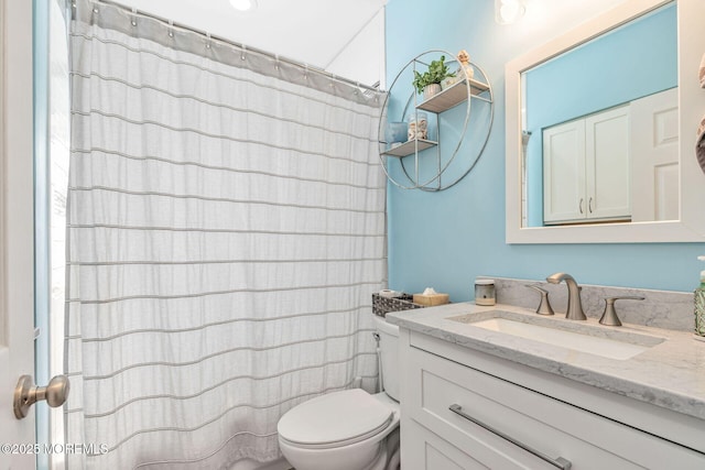 full bathroom featuring toilet, vanity, and curtained shower