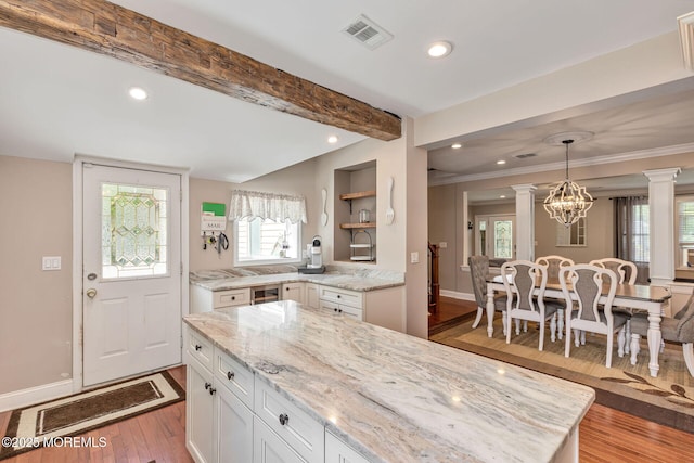 kitchen with decorative columns, white cabinets, recessed lighting, wood finished floors, and baseboards
