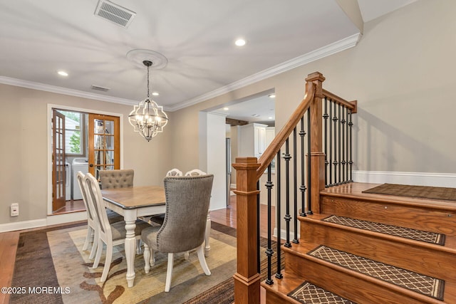 dining room with washer / dryer, a chandelier, ornamental molding, wood finished floors, and recessed lighting