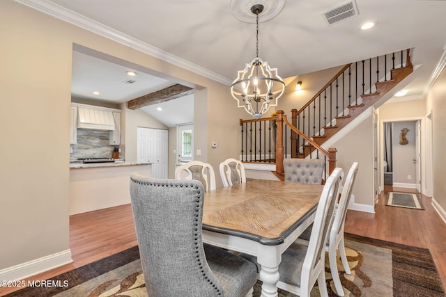 dining room with a chandelier, dark wood-style floors, stairway, lofted ceiling, and ornamental molding