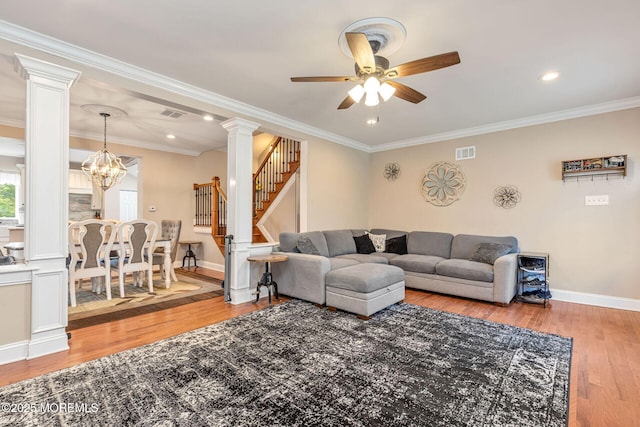 living area with ornate columns, a ceiling fan, stairs, hardwood / wood-style flooring, and baseboards