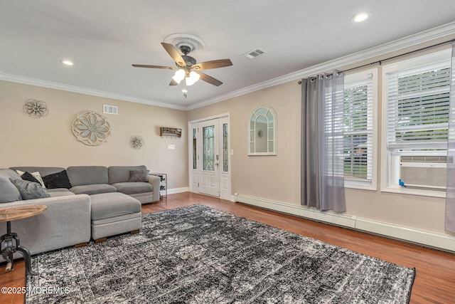 living area featuring a baseboard heating unit, wood finished floors, crown molding, a ceiling fan, and recessed lighting