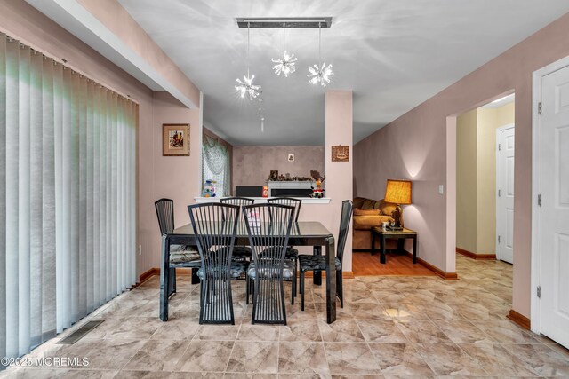 dining area featuring a chandelier and baseboards