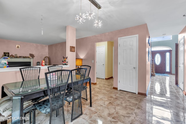 dining space featuring a chandelier and baseboards