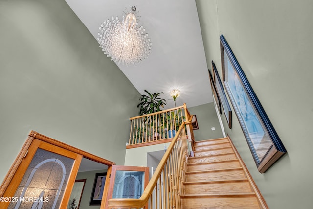 stairway with a high ceiling and a chandelier