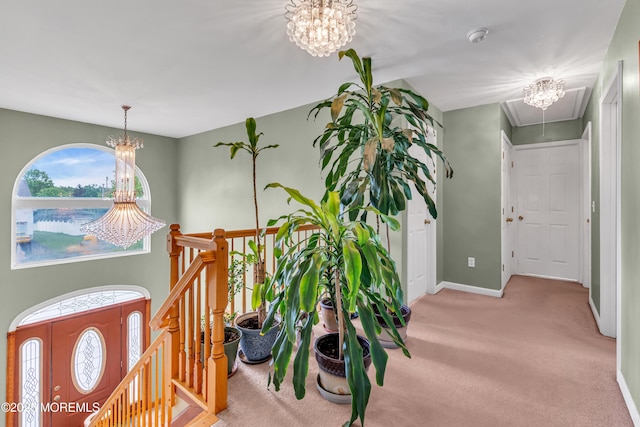 foyer featuring a chandelier, carpet, and baseboards