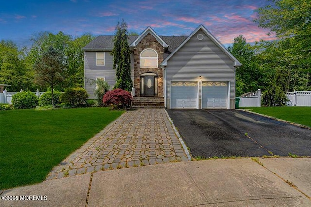 traditional-style home featuring asphalt driveway and stone siding