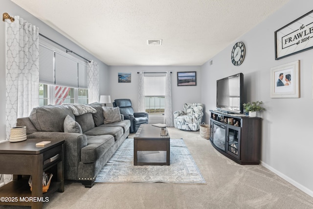 living room featuring carpet floors, a textured ceiling, and baseboards