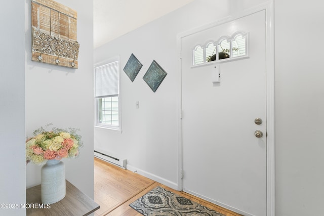entryway with baseboard heating, wood finished floors, and baseboards