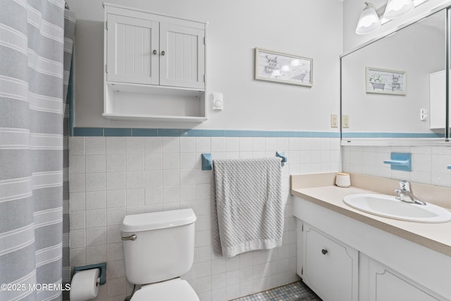 full bath featuring tile walls, toilet, wainscoting, vanity, and a shower with curtain