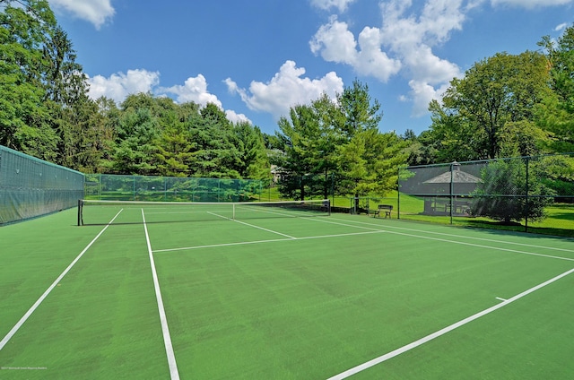 view of tennis court featuring fence