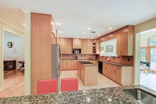 kitchen with black appliances, dark stone countertops, light brown cabinets, a center island, and open shelves