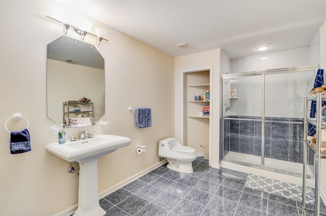 bathroom with toilet, a shower stall, tile patterned floors, and baseboards
