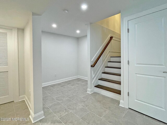 basement featuring recessed lighting, stairs, and baseboards
