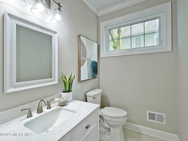 bathroom with crown molding, toilet, vanity, marble finish floors, and baseboards