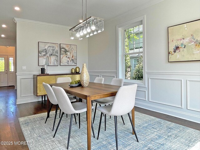 dining area featuring crown molding, a decorative wall, dark wood-style floors, healthy amount of natural light, and wainscoting