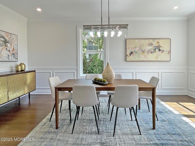 dining room with wood finished floors, a decorative wall, recessed lighting, ornamental molding, and a wainscoted wall