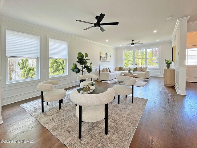 living room featuring ornamental molding, a decorative wall, ceiling fan, dark wood-style flooring, and recessed lighting