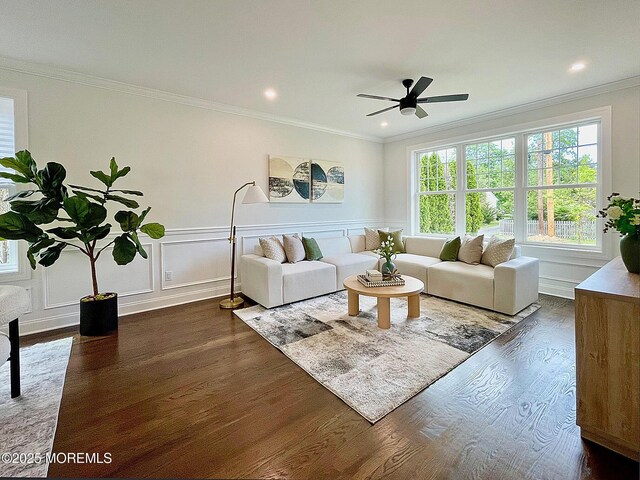 living room featuring dark wood-type flooring, ornamental molding, ceiling fan, recessed lighting, and a decorative wall
