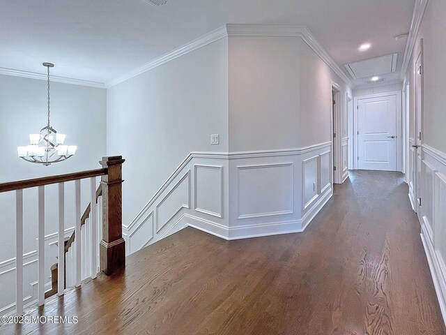 hallway with dark wood finished floors, a decorative wall, a chandelier, an upstairs landing, and recessed lighting