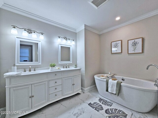 full bath featuring marble look tile flooring, double vanity, crown molding, a soaking tub, and baseboards