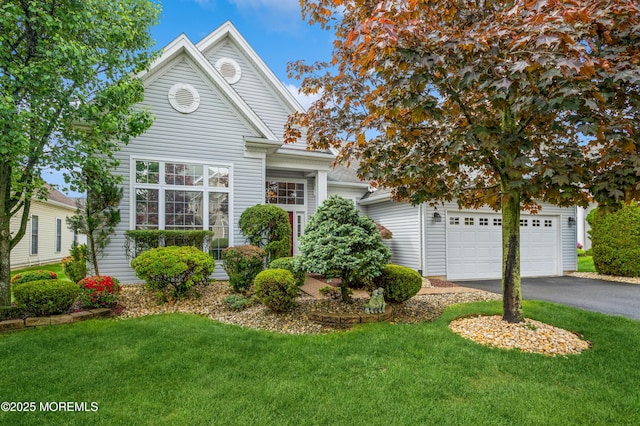 view of front of property with asphalt driveway, a front lawn, and a garage