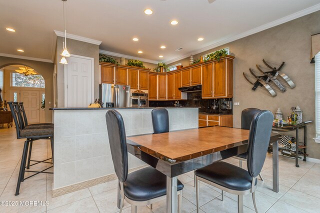 dining room featuring arched walkways, recessed lighting, ornamental molding, light tile patterned flooring, and baseboards