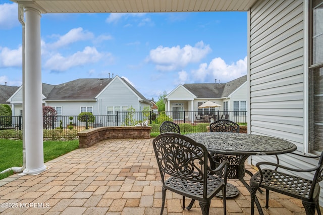 view of patio / terrace with a residential view, fence, and outdoor dining space