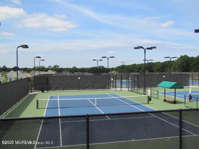 view of tennis court with fence and community basketball court