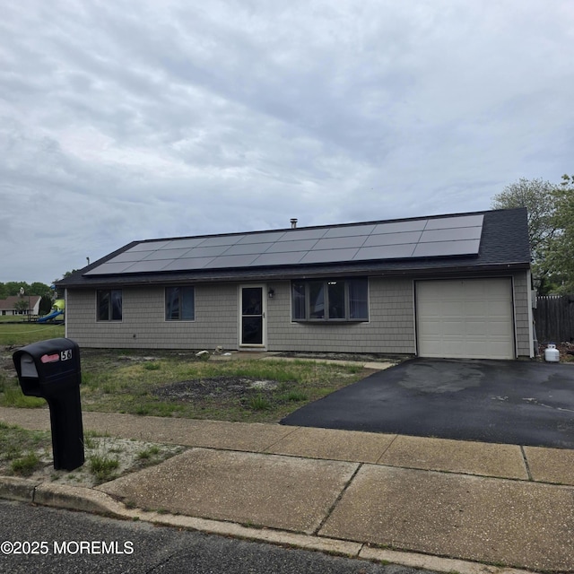 56 Georgetown Blvd, Barnegat, NJ 08005 - view of front of home with an attached garage, solar panels, and asphalt driveway