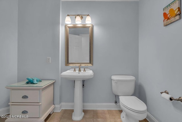 bathroom with baseboards and toilet