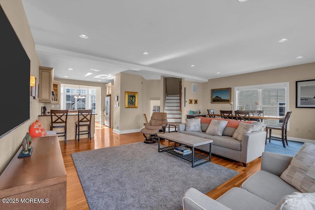 living area with stairway, light wood-style floors, baseboards, and recessed lighting