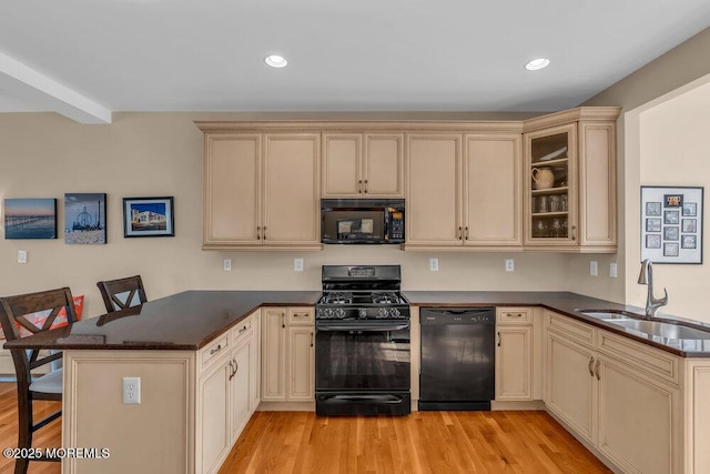 kitchen featuring black appliances, cream cabinetry, a peninsula, and recessed lighting