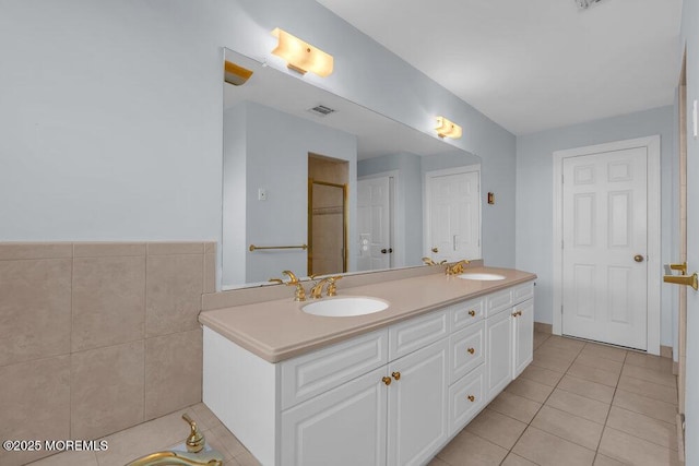 full bathroom featuring tile patterned floors, double vanity, and a shower