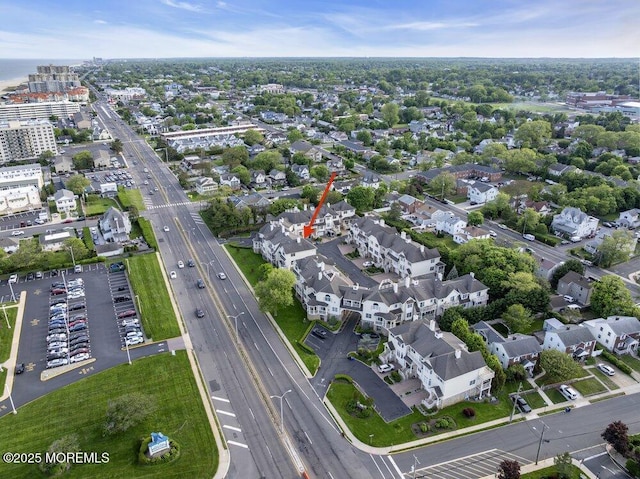 aerial view of property and surrounding area featuring a main thoroughfare and nearby urban area