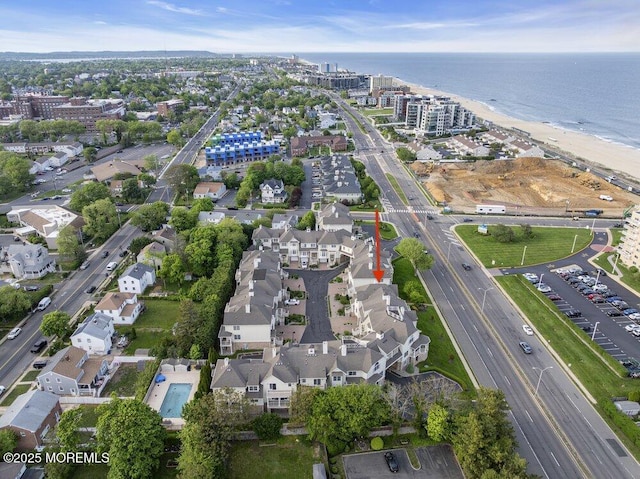 aerial view of property and surrounding area featuring a large body of water and a main thoroughfare
