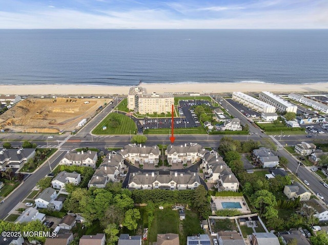 aerial view of property and surrounding area featuring unending shoreline and nearby suburban area