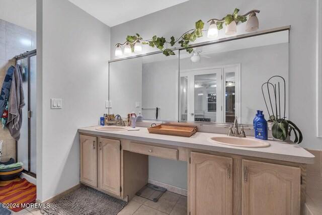bathroom featuring double vanity, a stall shower, and tile patterned flooring
