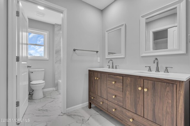 bathroom featuring marble look tile flooring, baseboards, toilet, and double vanity