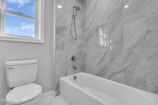 bathroom featuring marble look tiles, baseboards, toilet, and shower / tub combination