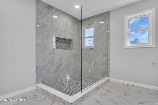 bathroom with baseboards, marble finish flooring, and a marble finish shower