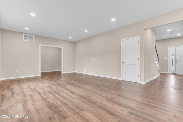 unfurnished living room featuring recessed lighting, light wood-style flooring, and baseboards